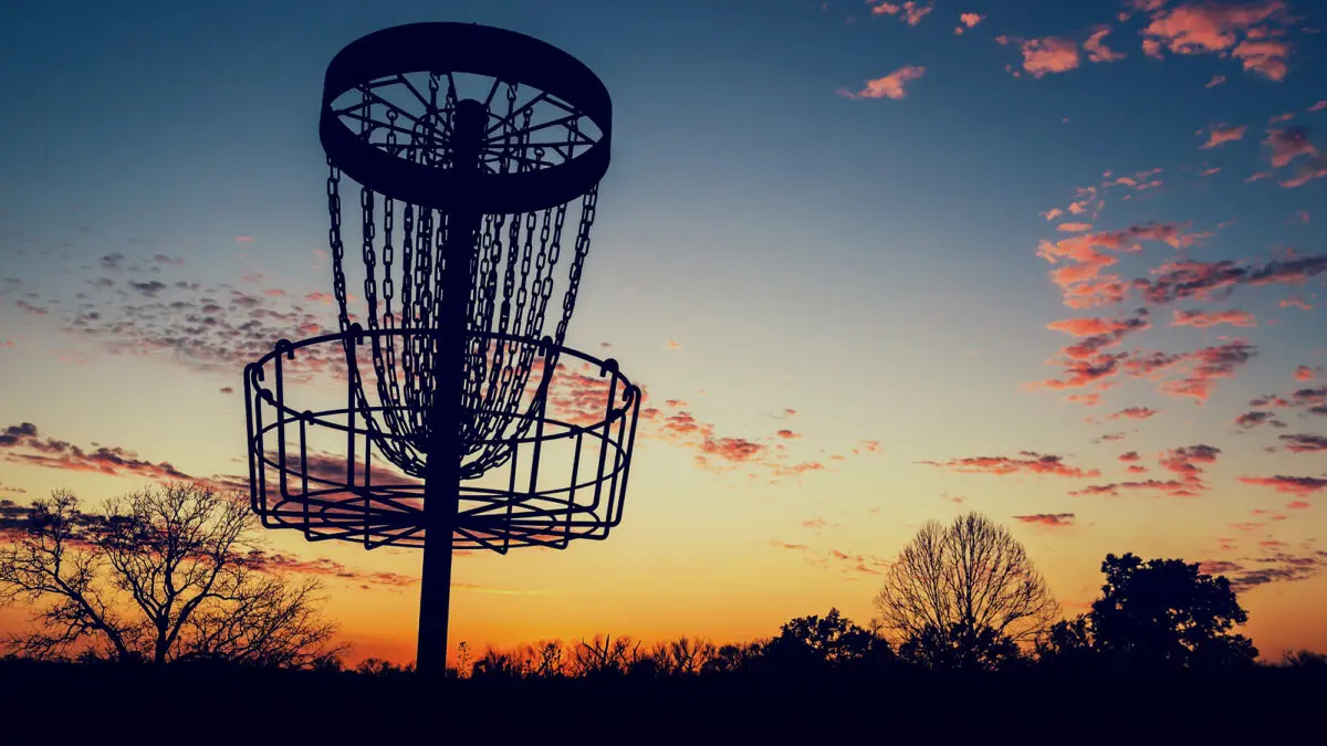close up of disc golf target basket at sunset
