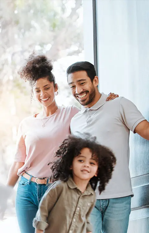 young family walking in the door of new home