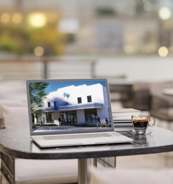 A laptop computer in a coffee shop, viewing the COLTON website.