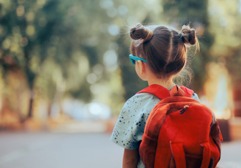 little girl with pigtails and red backpack