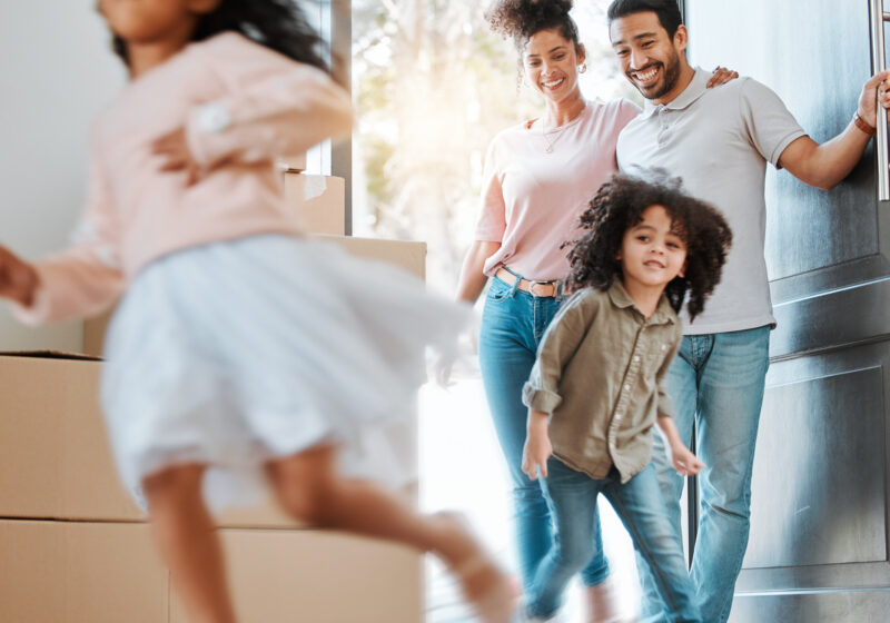 young family walking in the door of new home