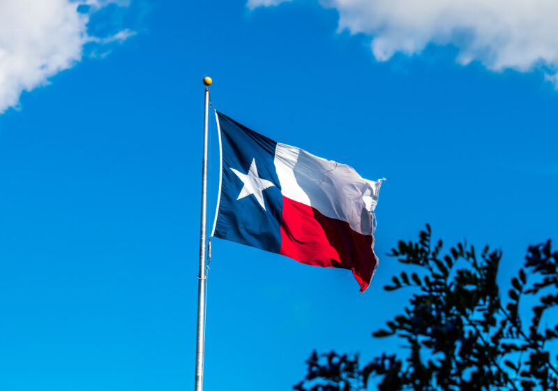 Texas flag with blue skies in the background